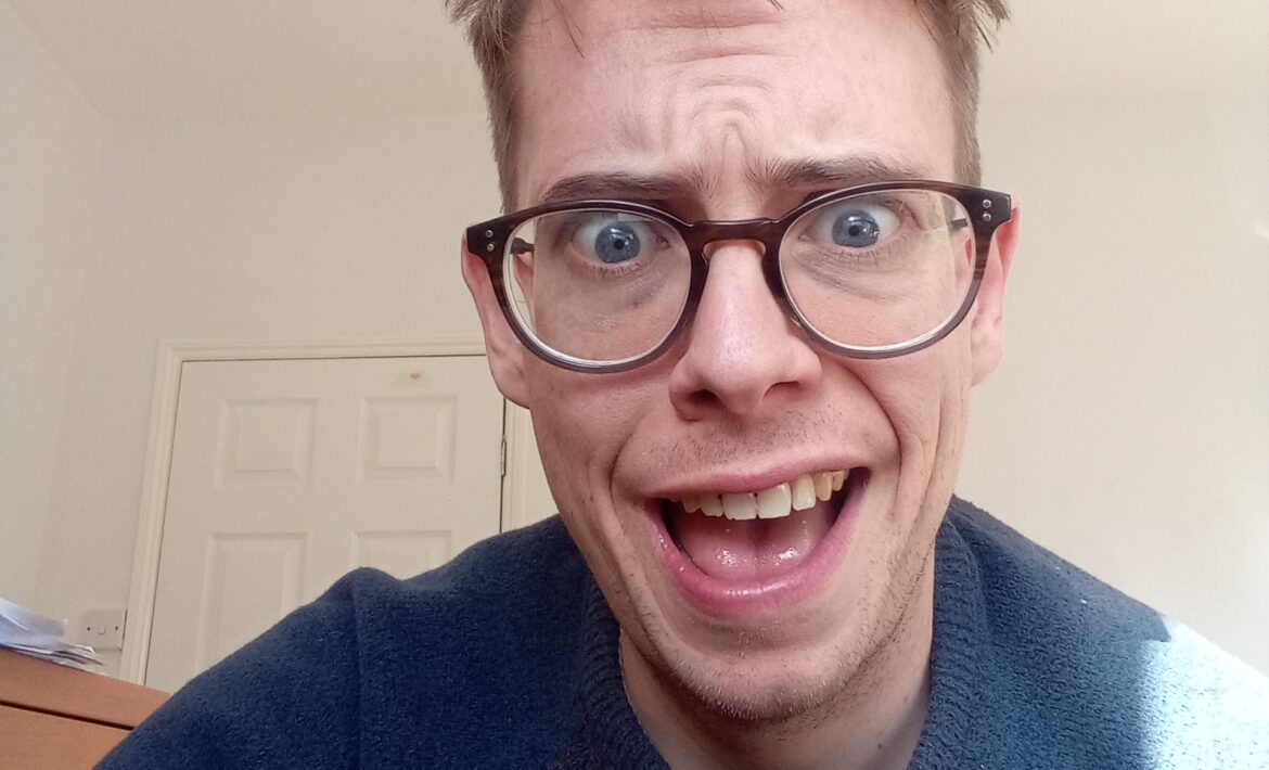 An image of Jorik, a white 33-year old autistic gay with soft hair, glasses and an expression of baffled hilarity on his face.