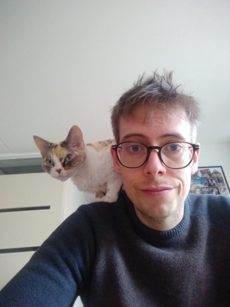 An image of Jorik with a cat on his shoulder.